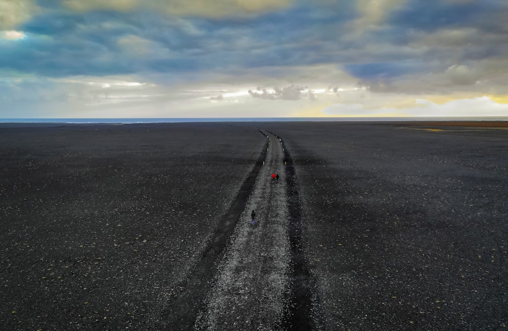 a road with a red object on it and a blue sky above