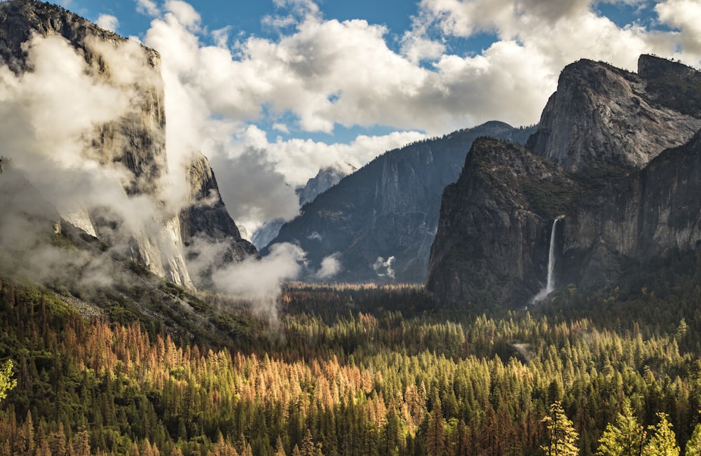 a waterfall in a valley between mountains