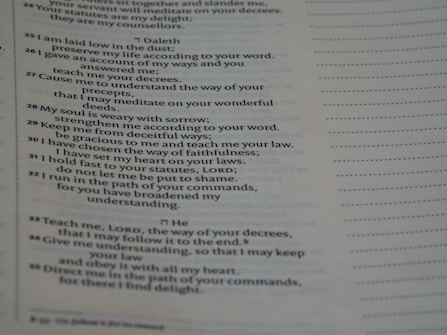 A close-up view of a printed page containing text in poetic format. The text appears to be organized in verses or stanzas, containing religious or spiritual content. The font is clear, and the page has margins with dotted lines on the side, possibly indicating space for notes.