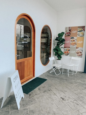 A wooden sign with the words 'Café da Manhã Colonial Artesanal' hanging near the entrance.