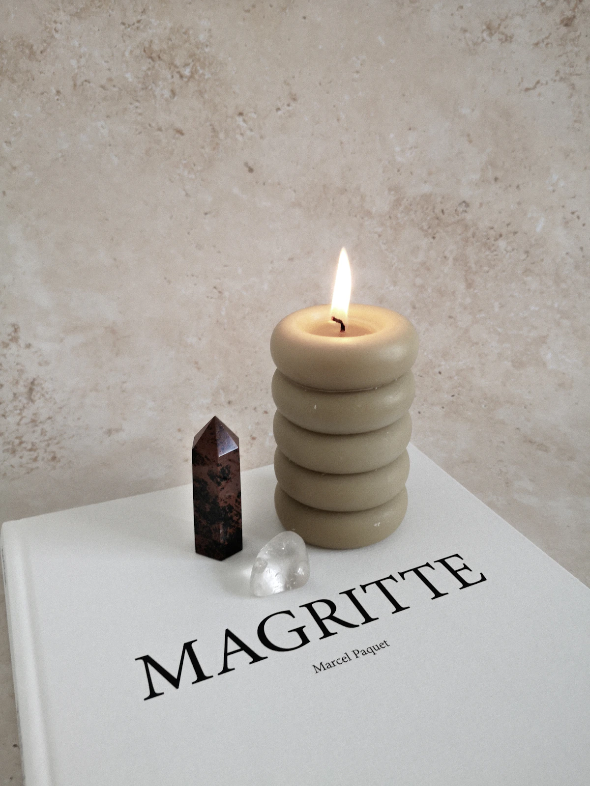 A candle styled with objects on a table