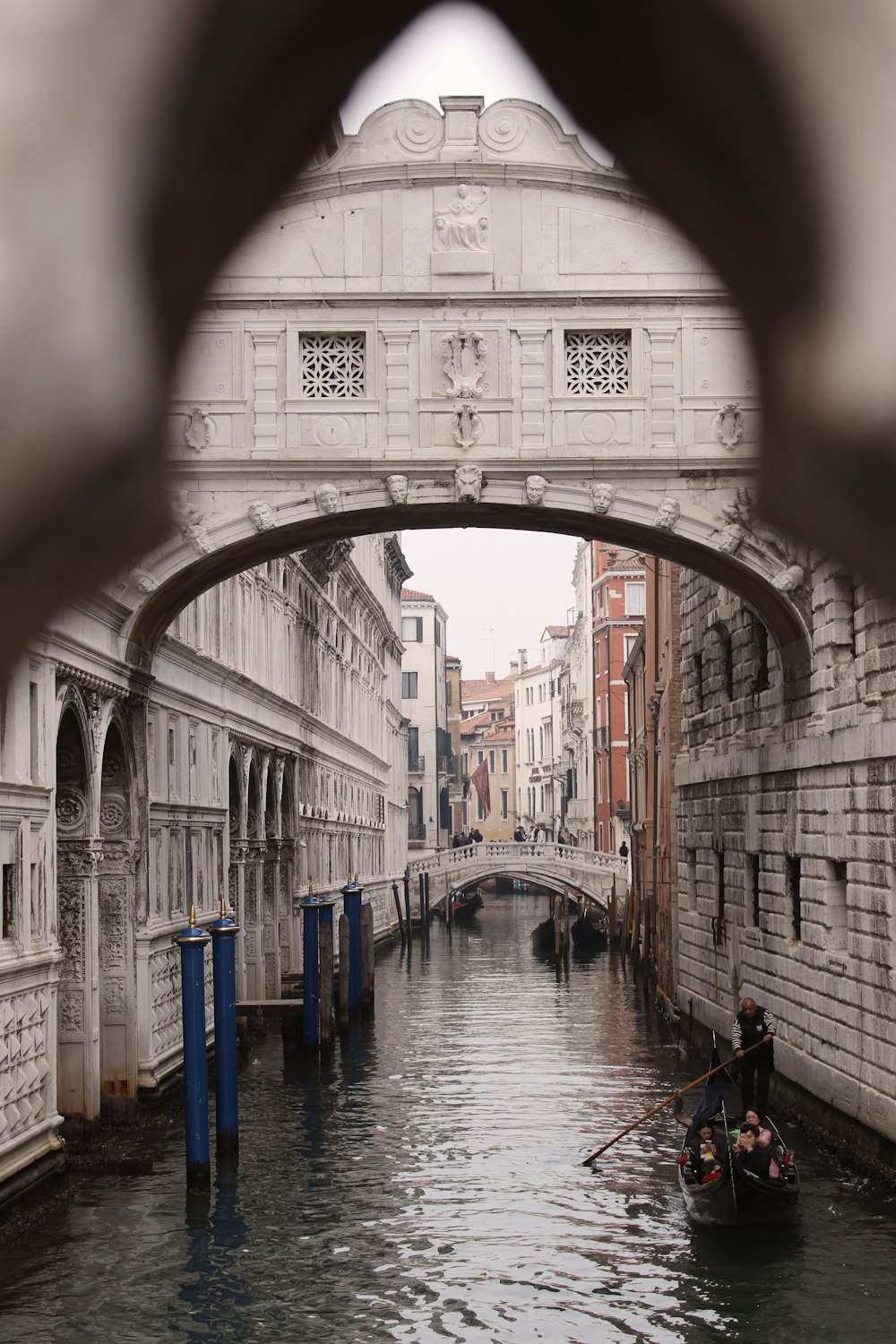 a boat in a canal with Bridge of Sighs in the background