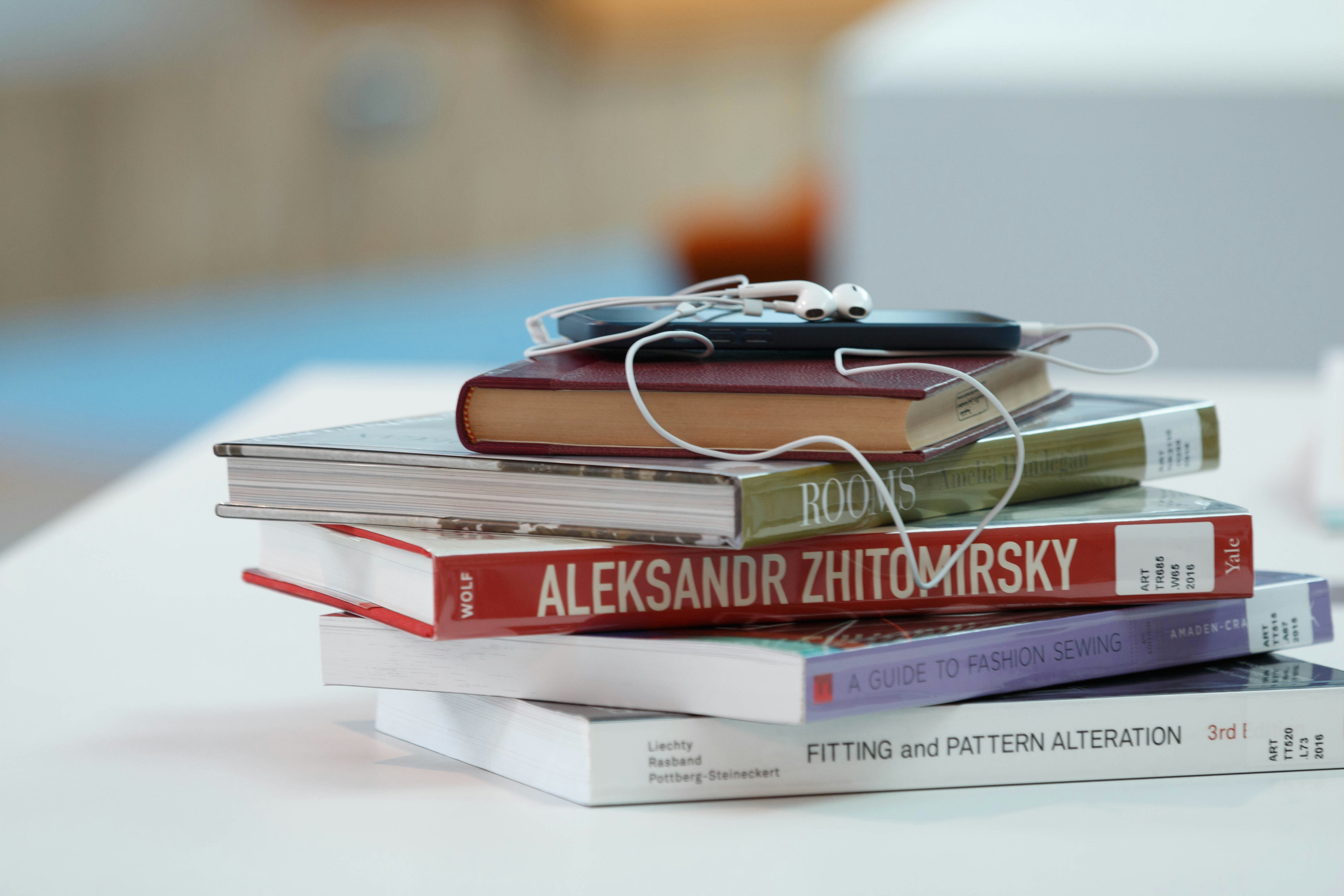 Stack of books with earbud headphones on top