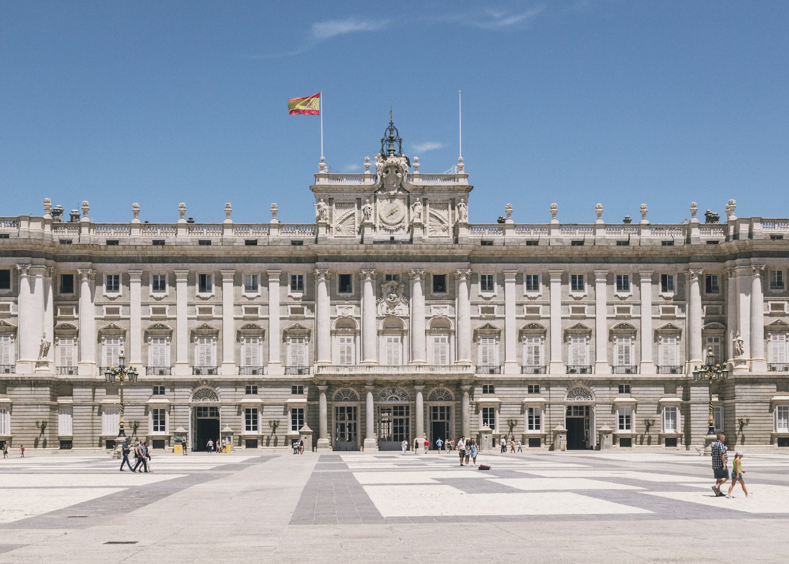 Facade of the Royal Palace of Madrid with the Spanish flag flying above the entrance