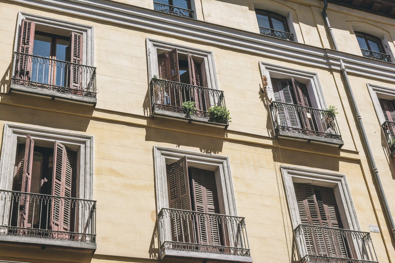 Fachada de Madrid con balcones de hierro forjado y contraventanas