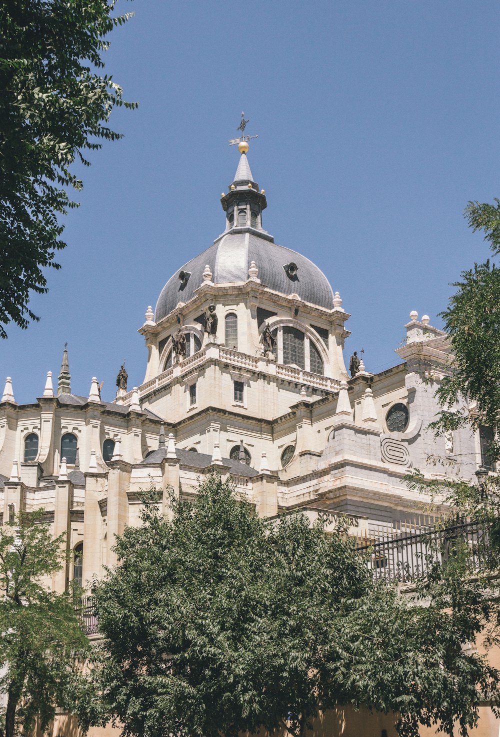 a large building with a dome and trees in front of it