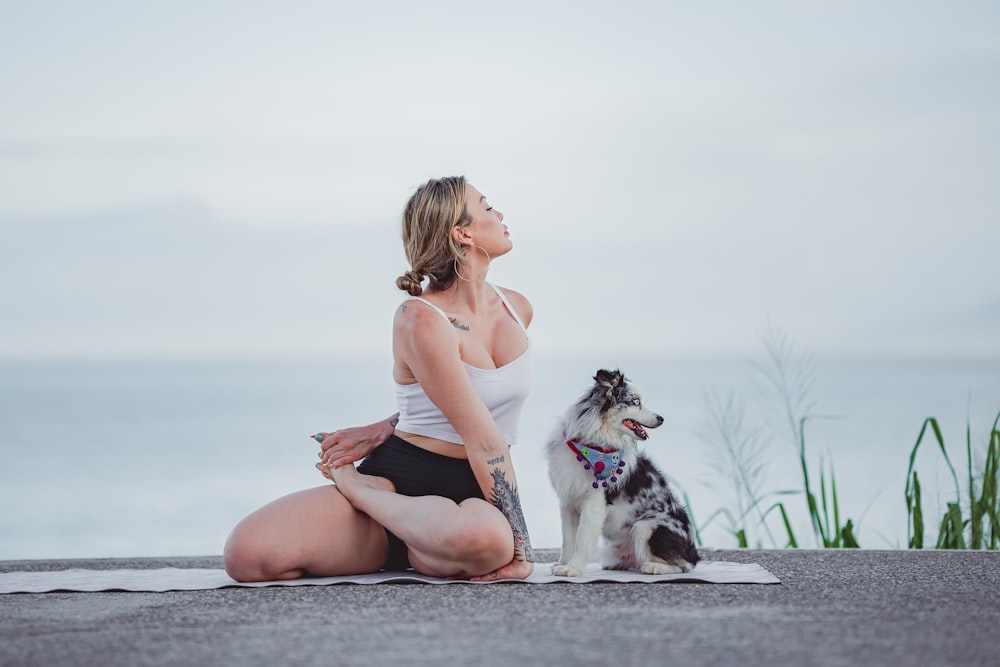 a woman sitting on a rock with a dog