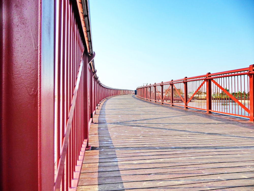 a wooden walkway with red railings