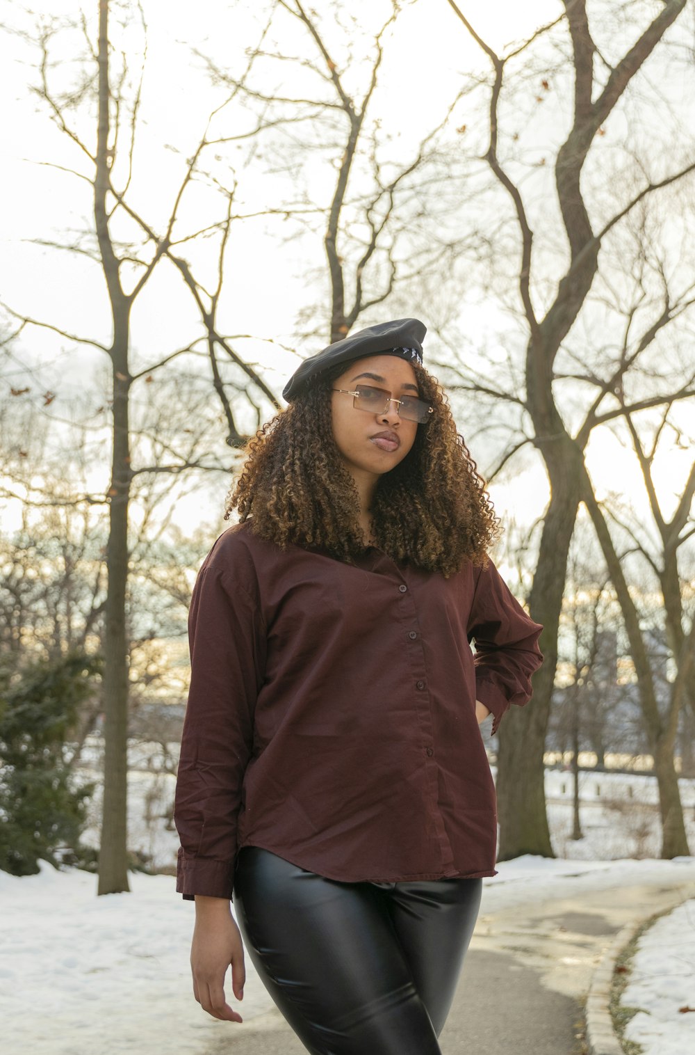 a woman wearing a red coat and glasses standing in the snow