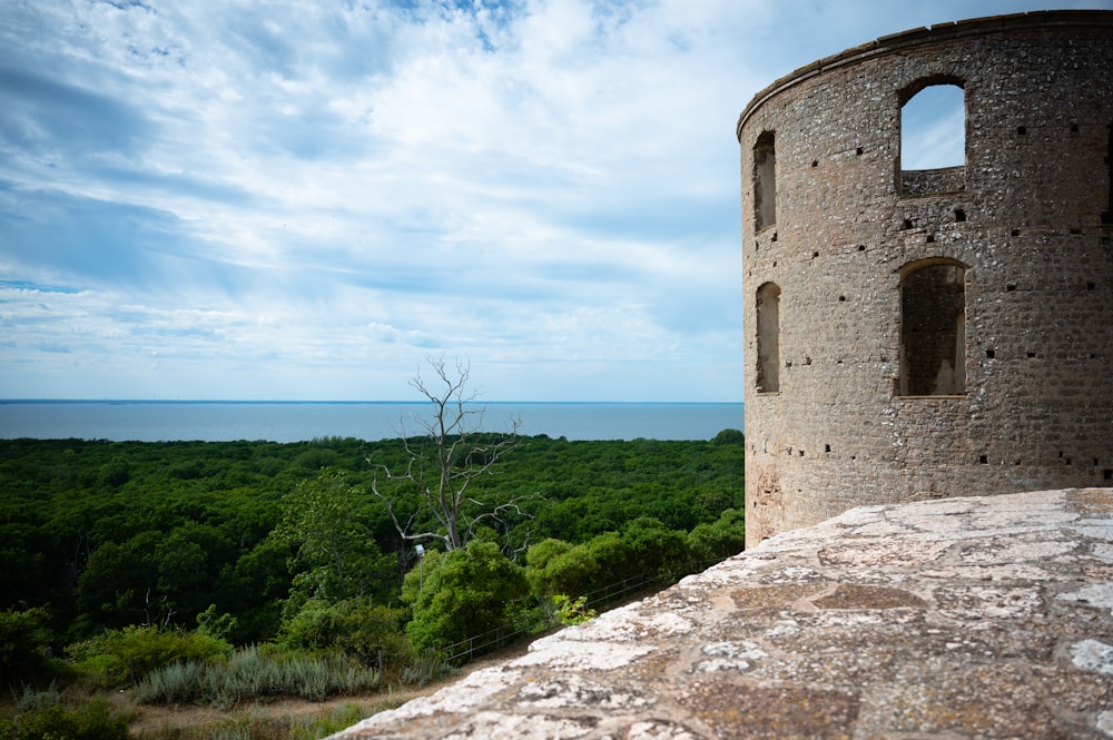 un bâtiment en pierre avec une colline et des arbres en arrière-plan