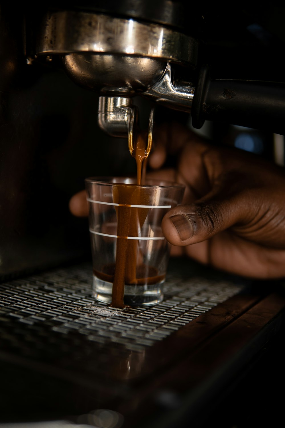 a hand pouring a liquid into a glass