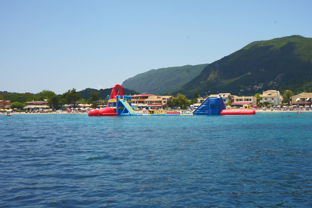 a body of water with a slide and buildings in the background