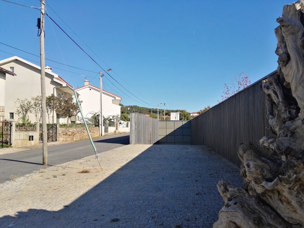 a road with a fence and buildings along it