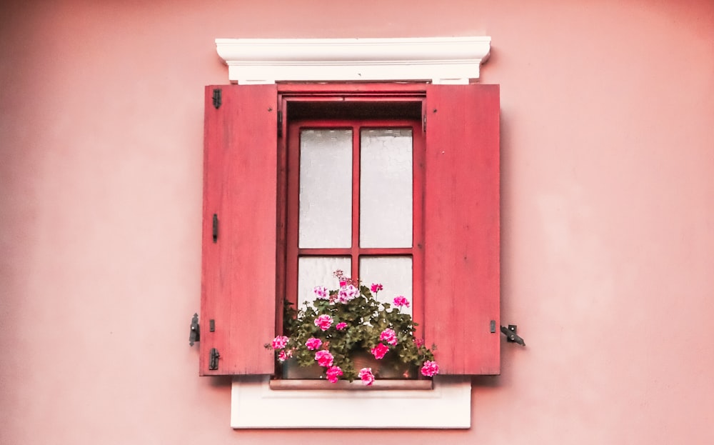 a window with a red frame and a plant in it