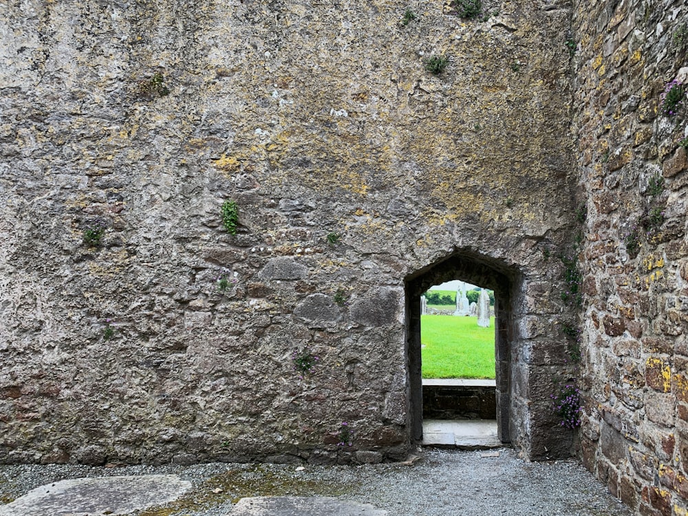 a stone building with a grass field