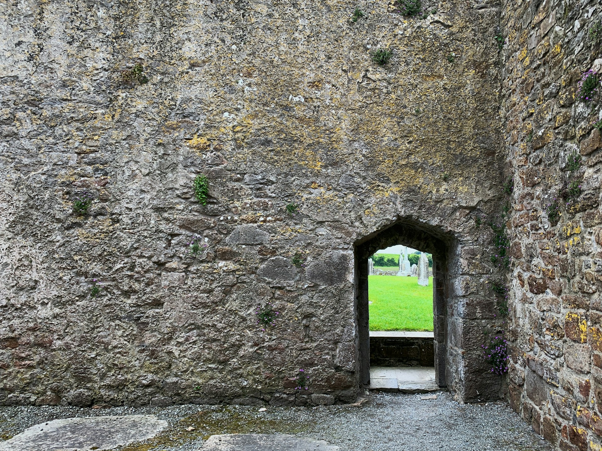 a stone building with a grass field