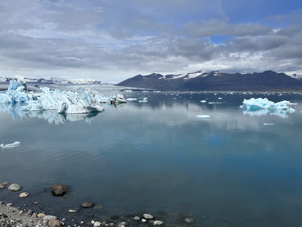 uno specchio d'acqua con ghiaccio e neve sul lato