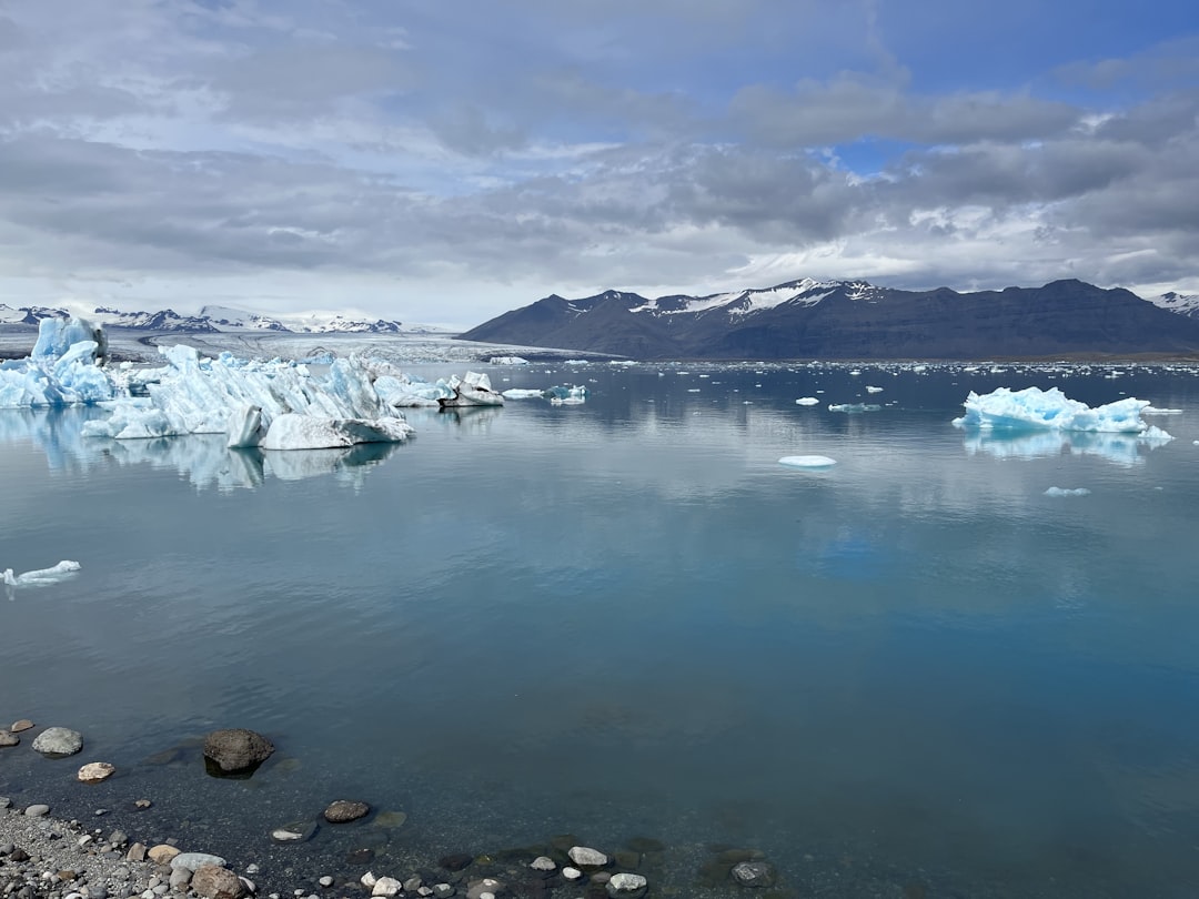 a body of water with ice and snow on the side,