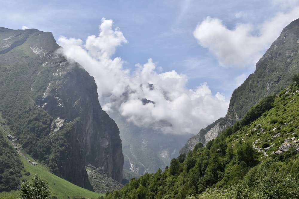 a valley between mountains with clouds