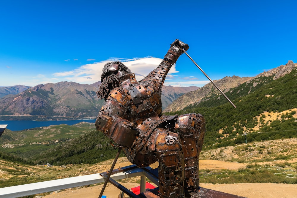 Eine Statue einer Person mit einer Waffe auf einem Berg