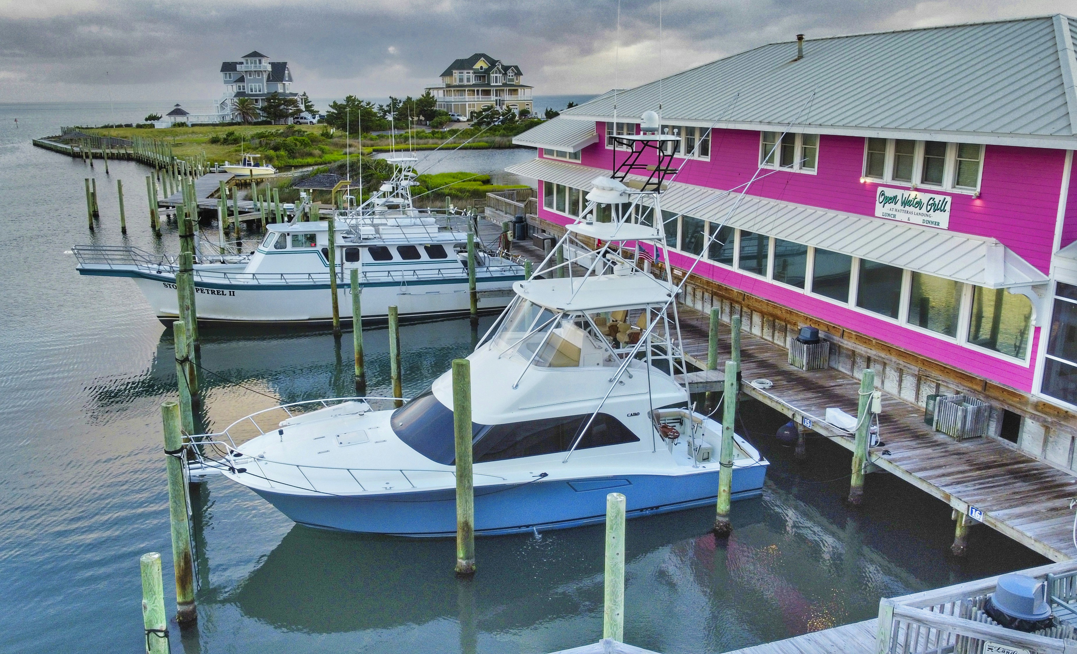 a couple of boats docked at a pier, Charter boats docked at Hatteras Landing at the Outer Banks of the North Carolina coast.