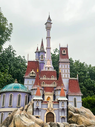 A fantasy castle built from blocks, surrounded by mythical creatures and lush greenery.
