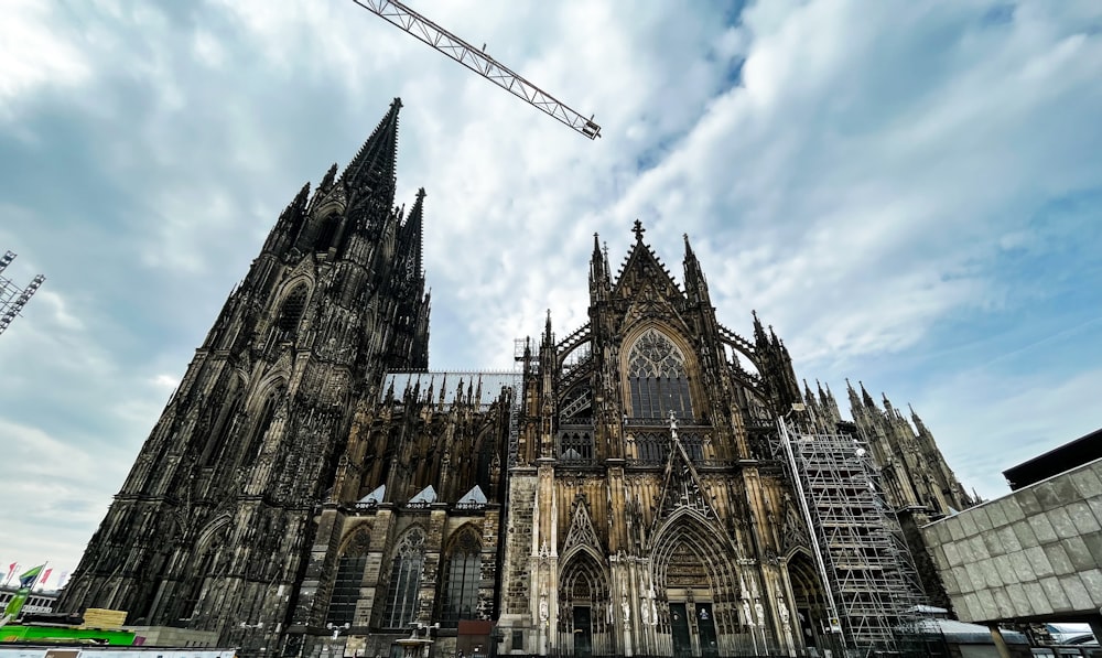 a large building under construction with Cologne Cathedral in the background