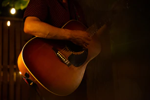 An intimate setting with a guitarist playing softly by candlelight.