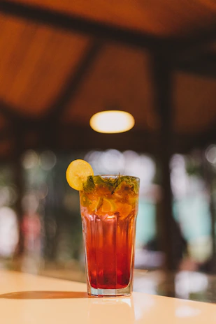 A stylish shot of saffron-infused juice with fresh herbs and citrus slices arranged artfully around it.