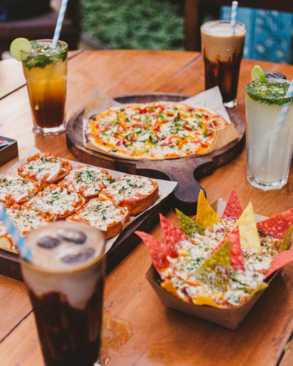 a table with pizzas and drinks