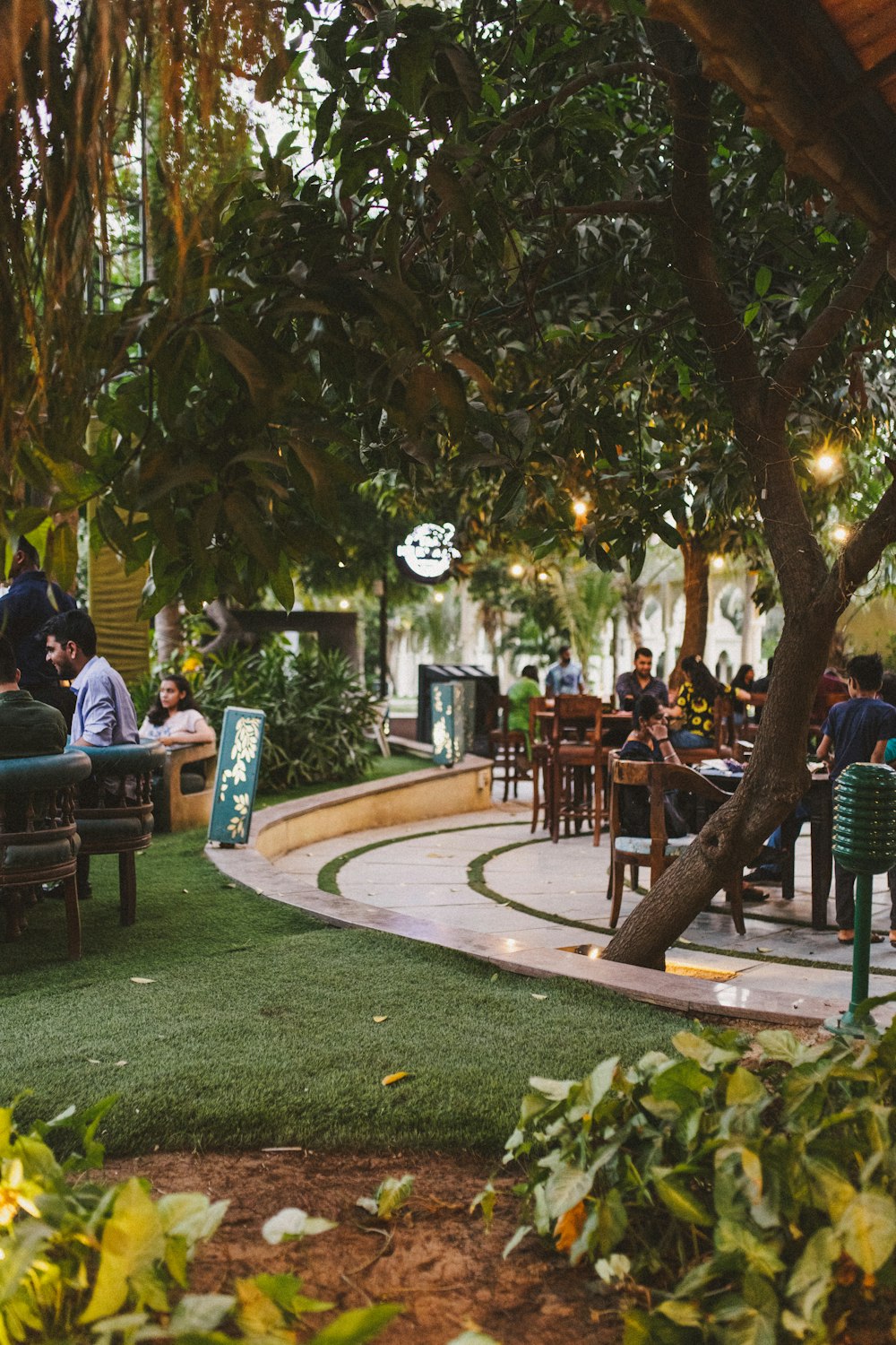 a group of people sitting at tables in a park