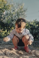 Children observing insects with magnifying glasses in a natural setting.
