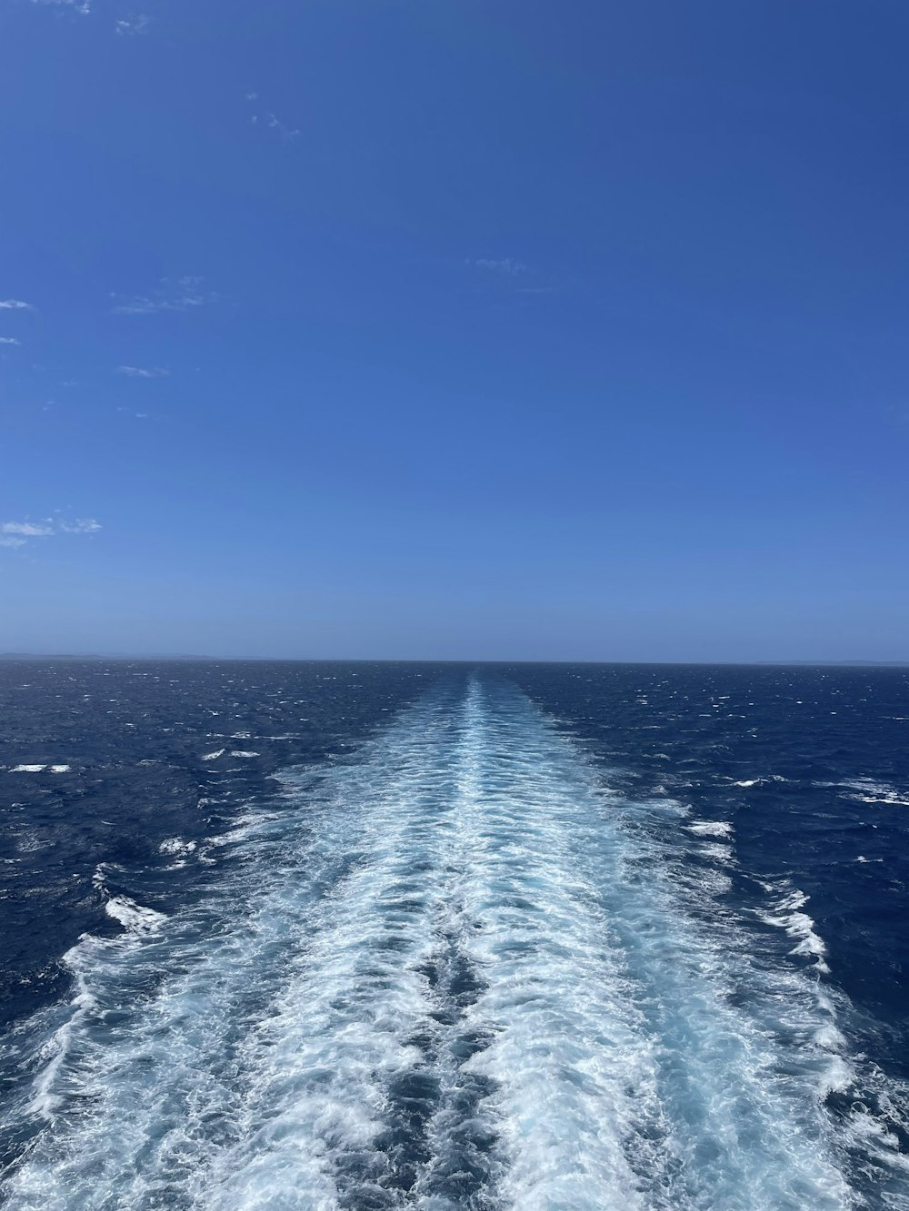 a body of water with a blue sky above it