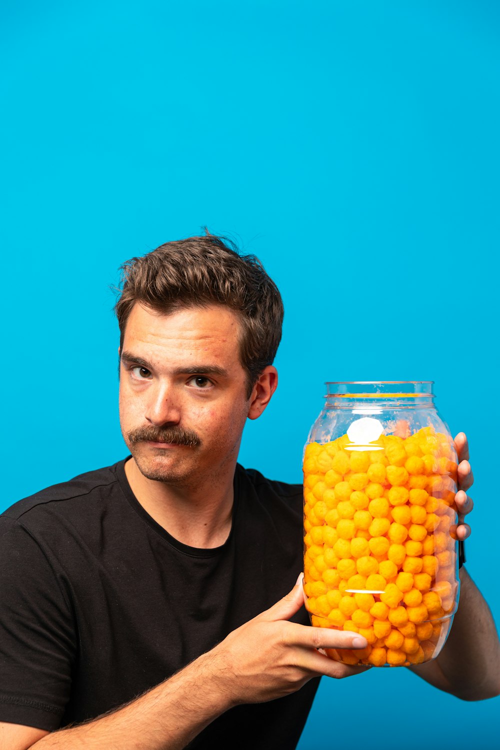 a man holding a container of oranges
