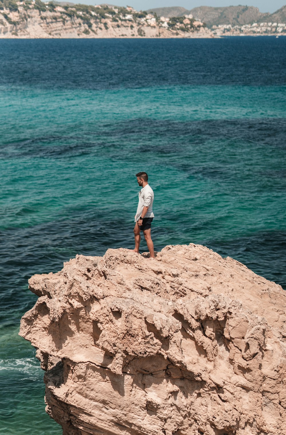 a man standing on a rock in the water