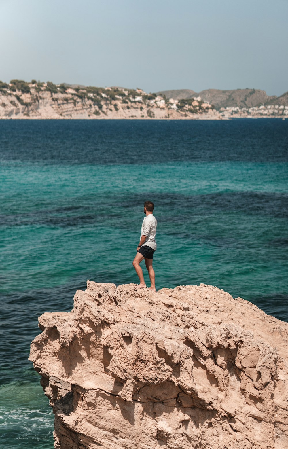 a man standing on a rock in the water