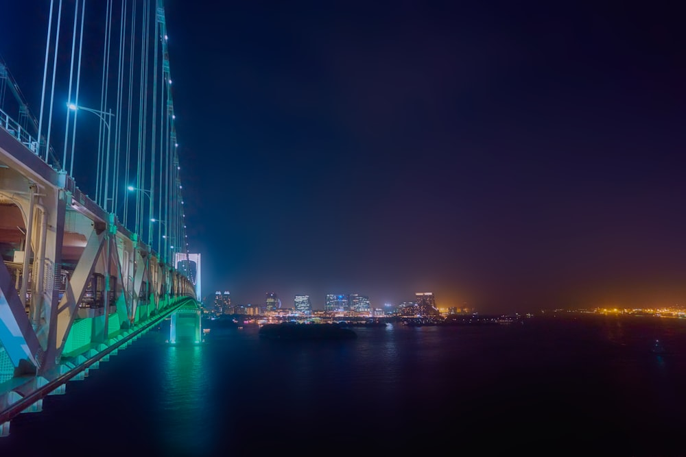 a bridge over water with a city in the background