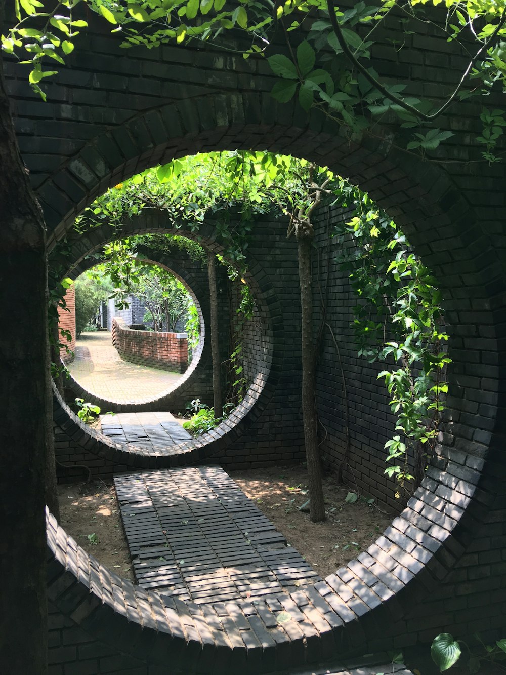 a brick archway with a basket and plants growing in it