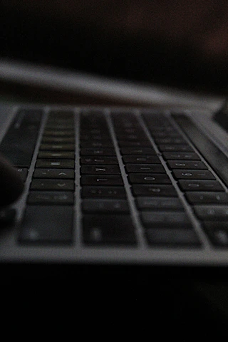 Close-up of hands typing on a sleek modern keyboard with soft natural light.