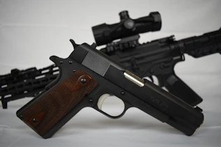 a black gun with a brown handle
