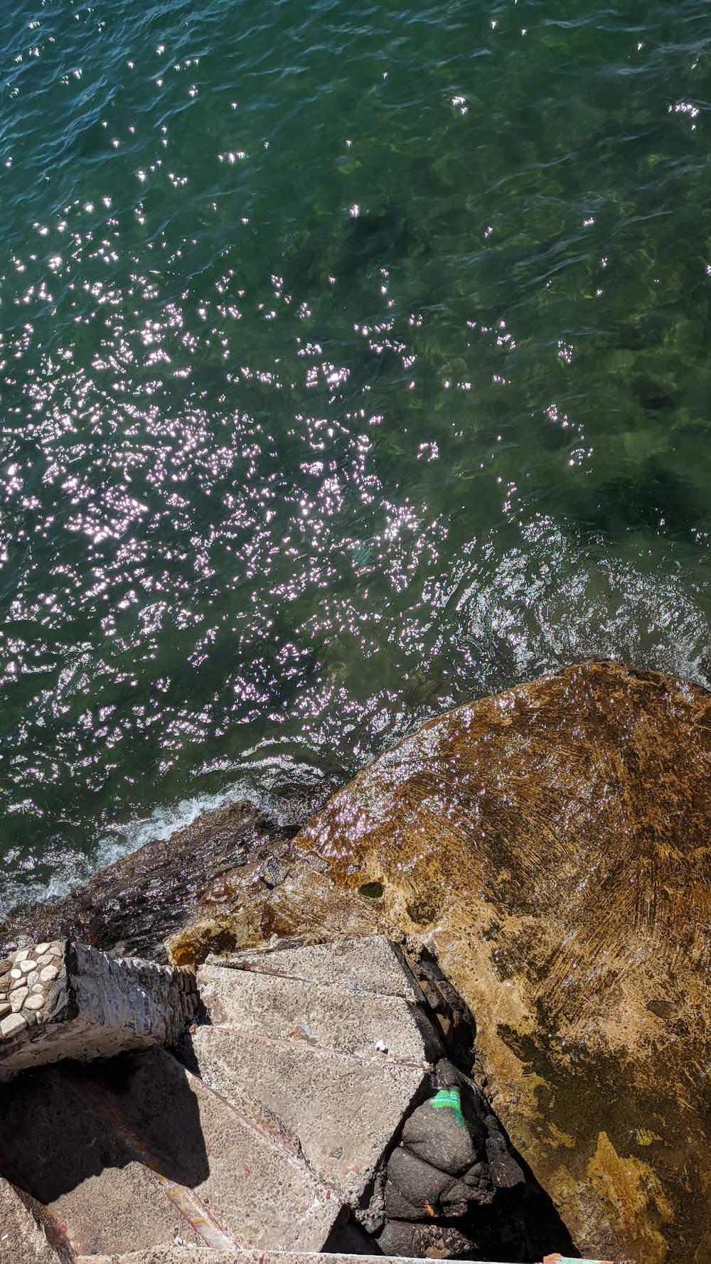 a body of water with rocks and a rock in the foreground