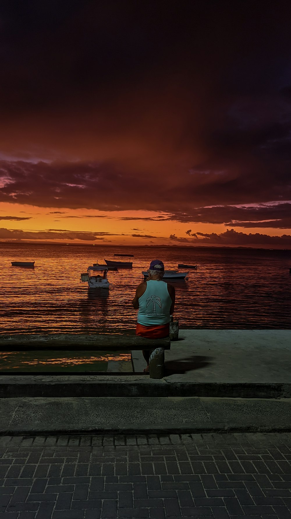 a person sitting on a bench looking at the water