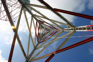 Engineer reviewing detailed structural blueprints for a telecommunications tower on a sunny day.