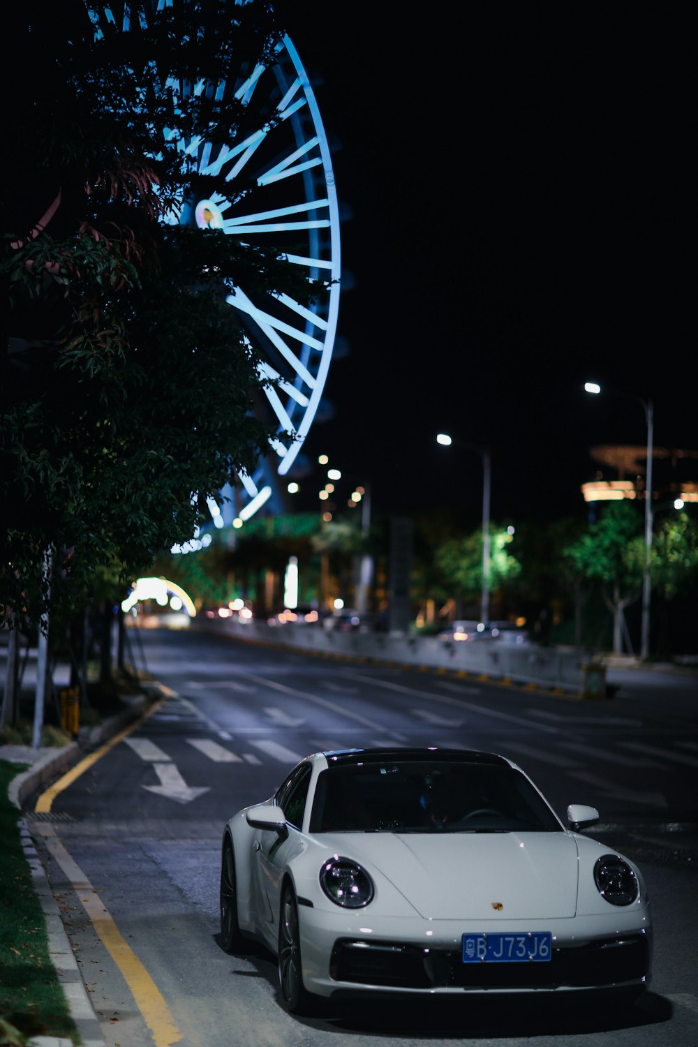 a white car on a street at night