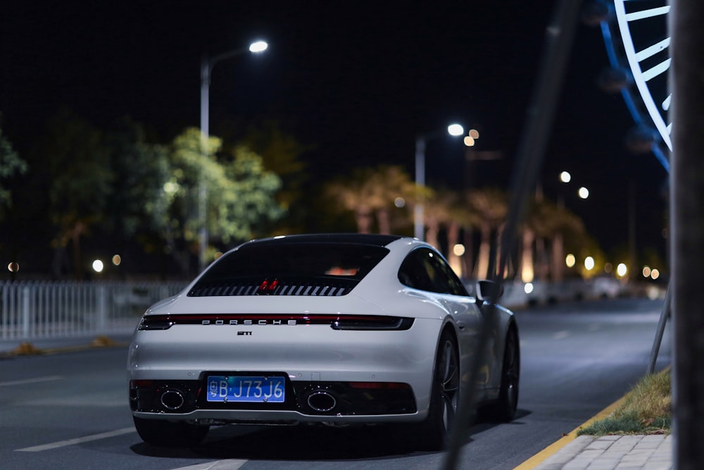 a white car on a road at night