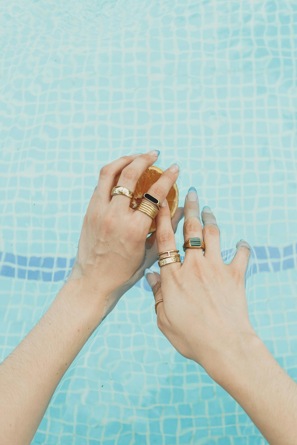 a pair of hands with wedding rings