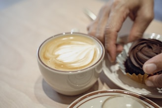 Happy customer enjoying a cup of tea and chocolate in a cozy café setting.
