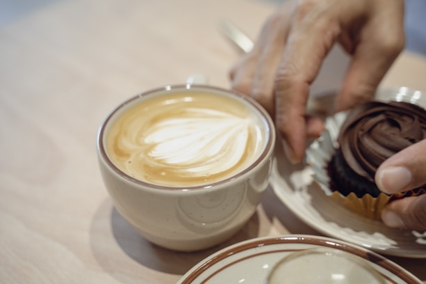 Happy customer enjoying a cup of tea and chocolate in a cozy café setting.