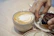 Happy customer enjoying a coffee and cheese tasting session in a cozy setting.