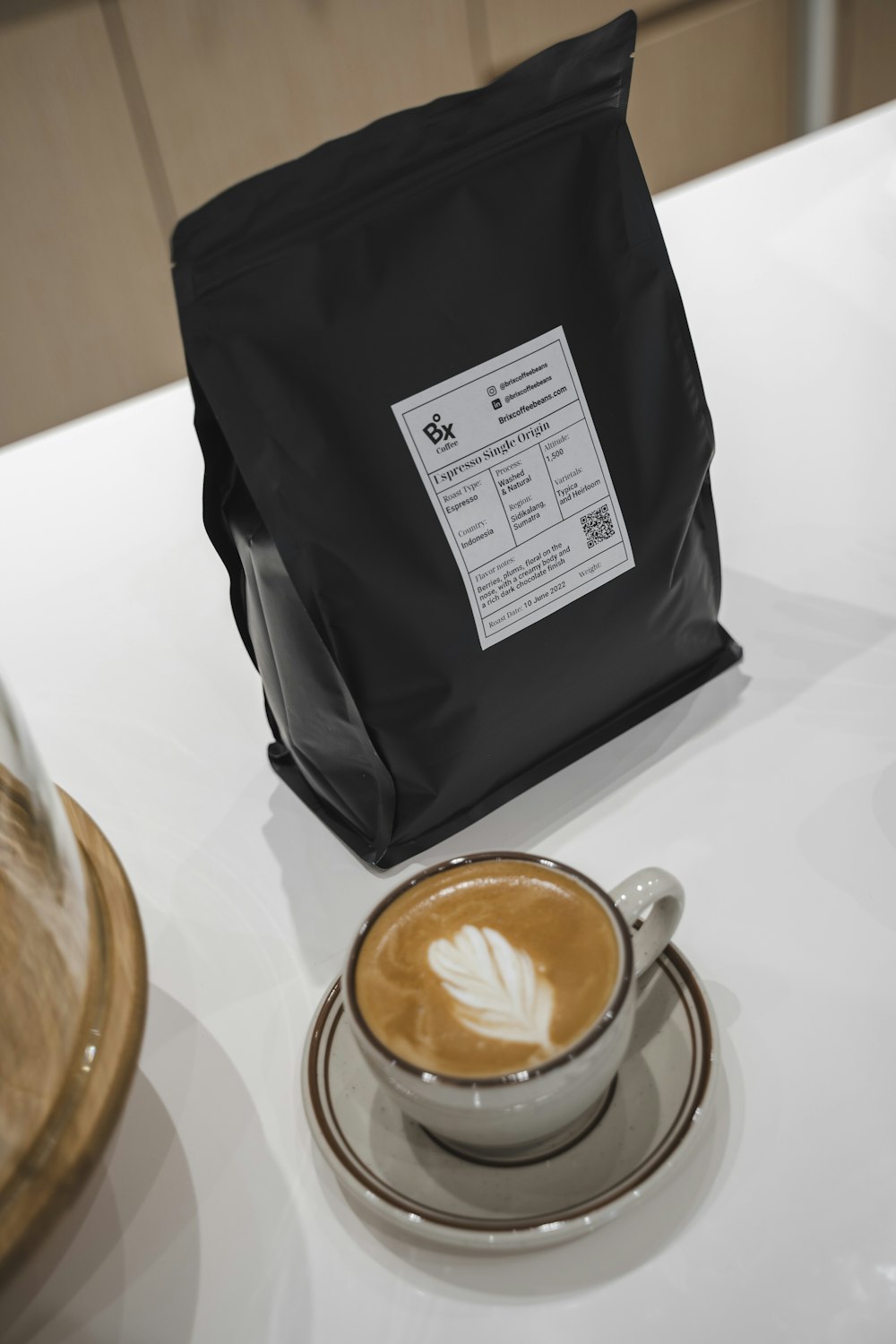 a black bag with a white label and a cup of coffee